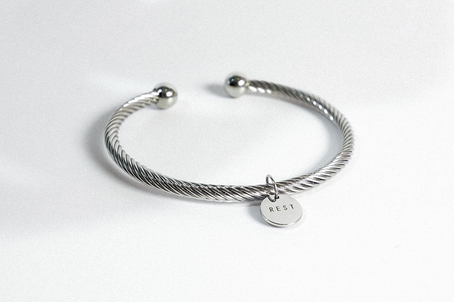 Rope bracelet with engraved pendant rest in silver color